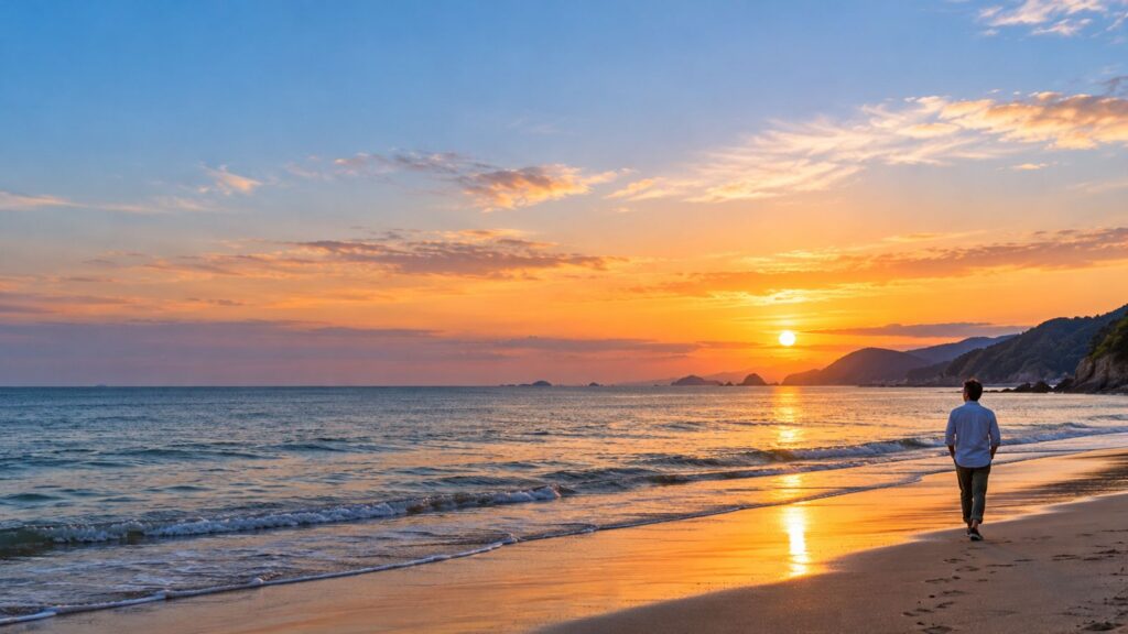 夕日の浜辺を歩く人の後ろ姿